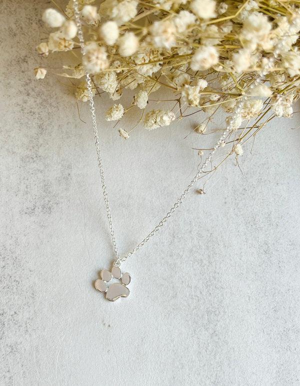 Elegante zilveren hanger met pootafdruk aan een ketting